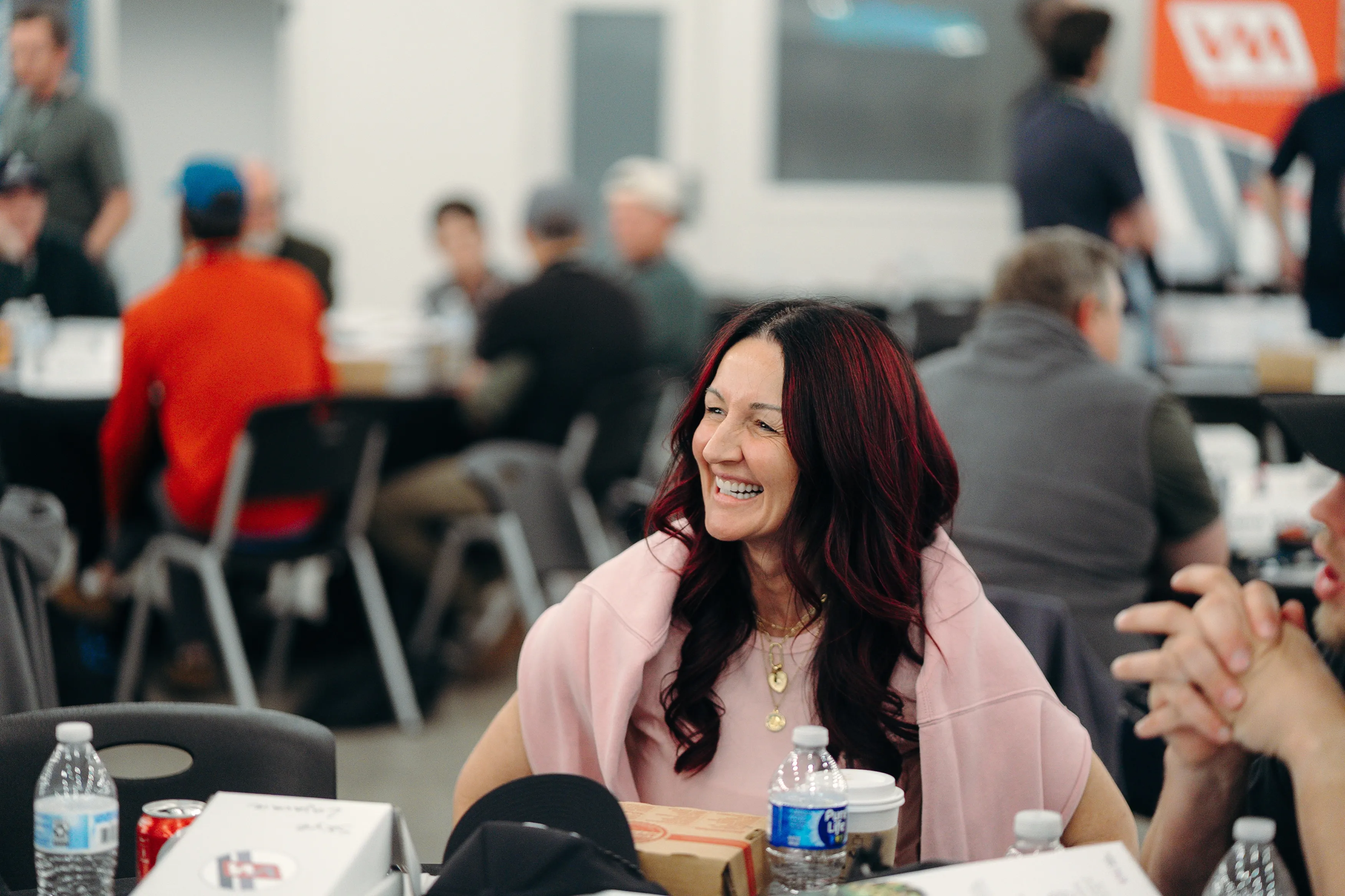 A pest control business owner laughing with others at a Bug Bux event