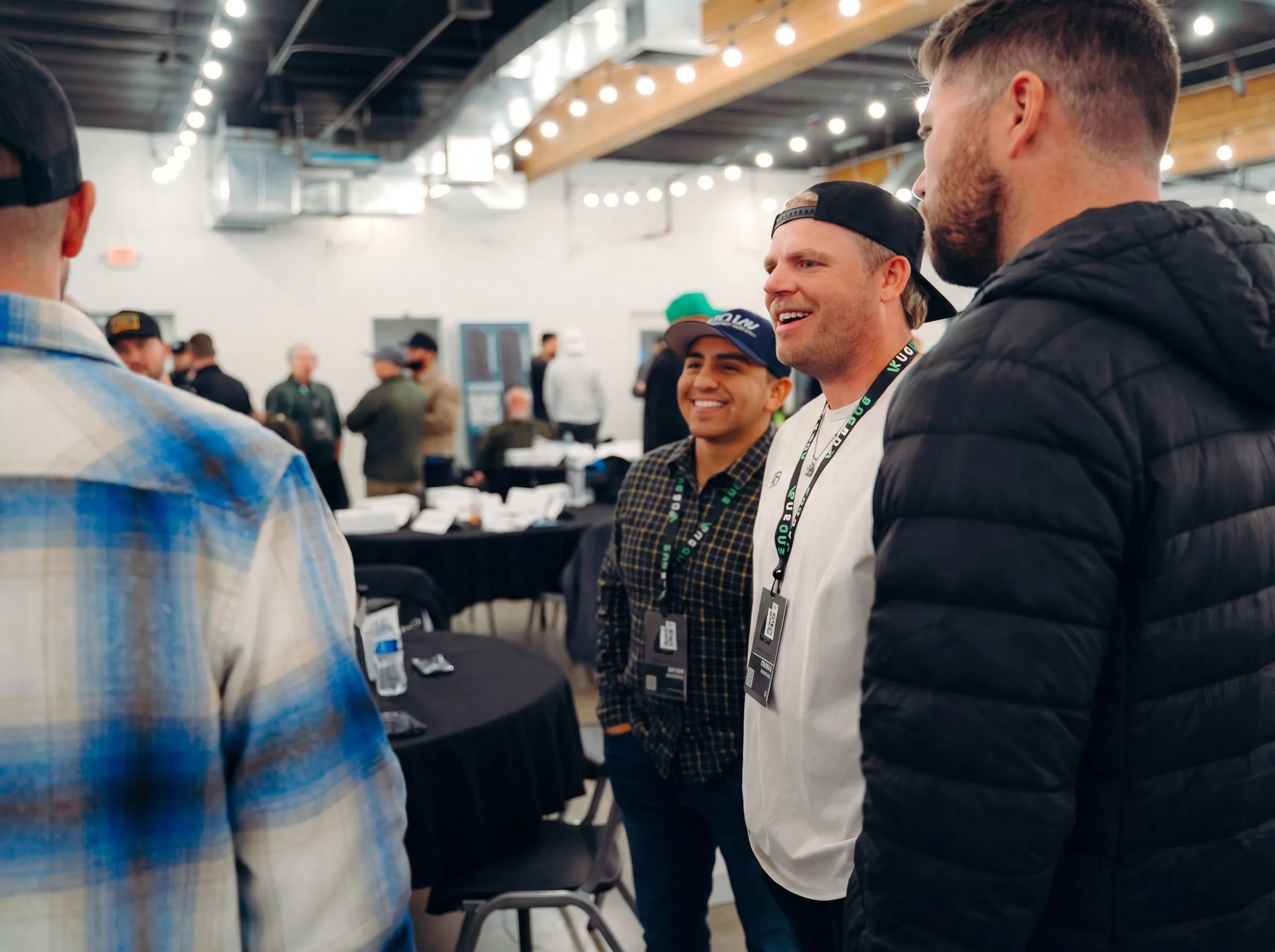 Pest control owners talking and laughing together at a Bug Bux event