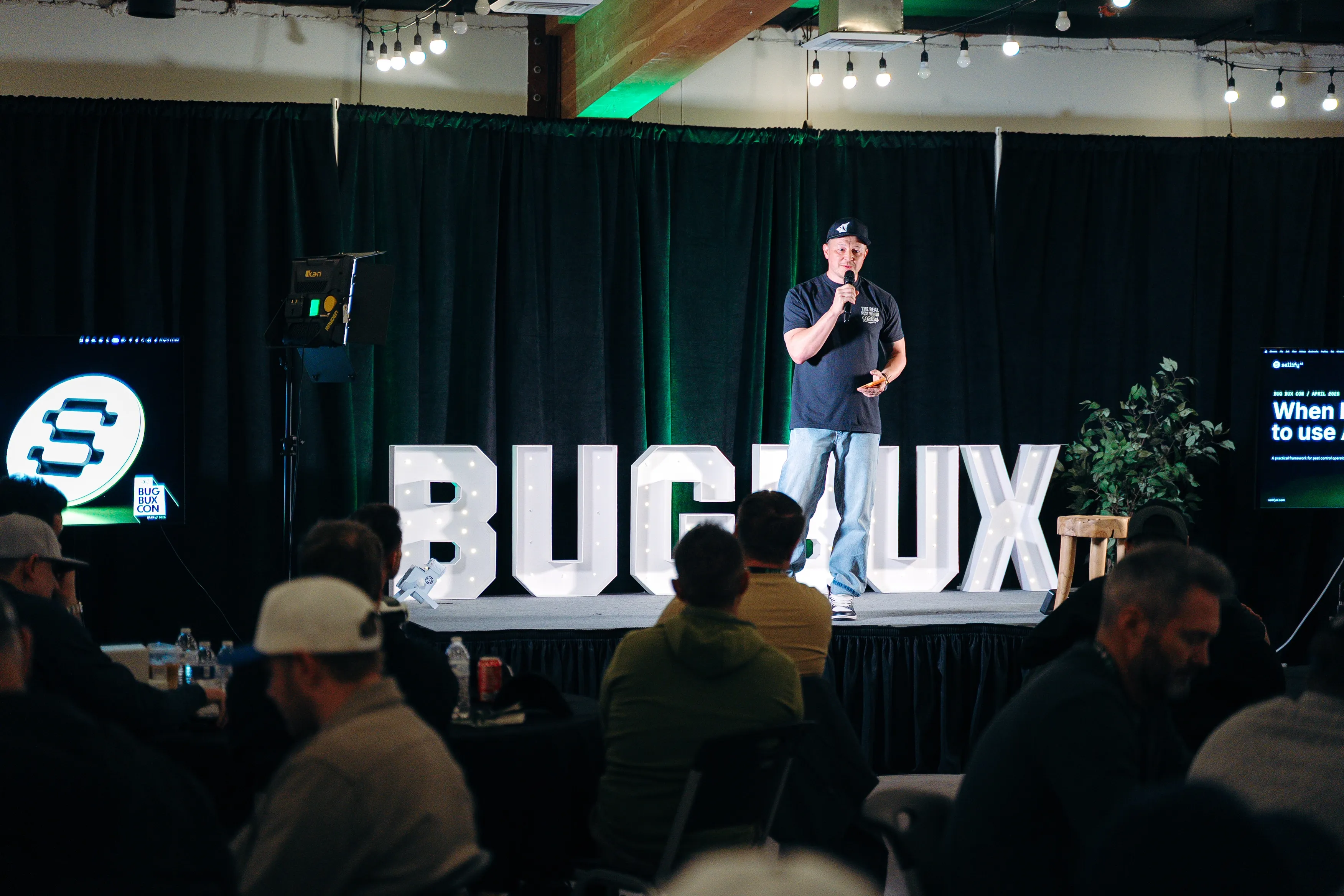A speaker presenting on stage at Bug Bux Con