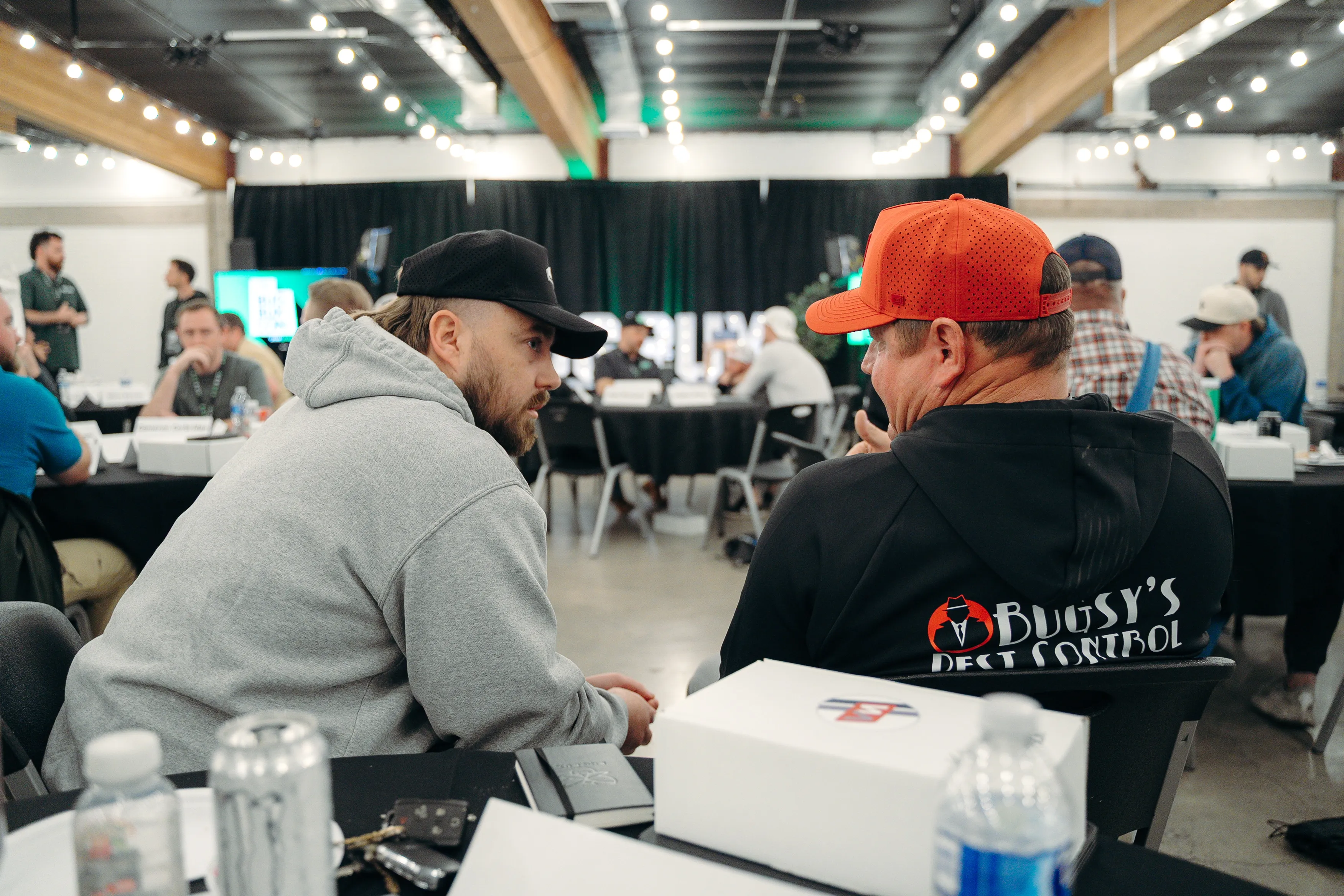 Pest control owners talking at a table during Bug Bux Con