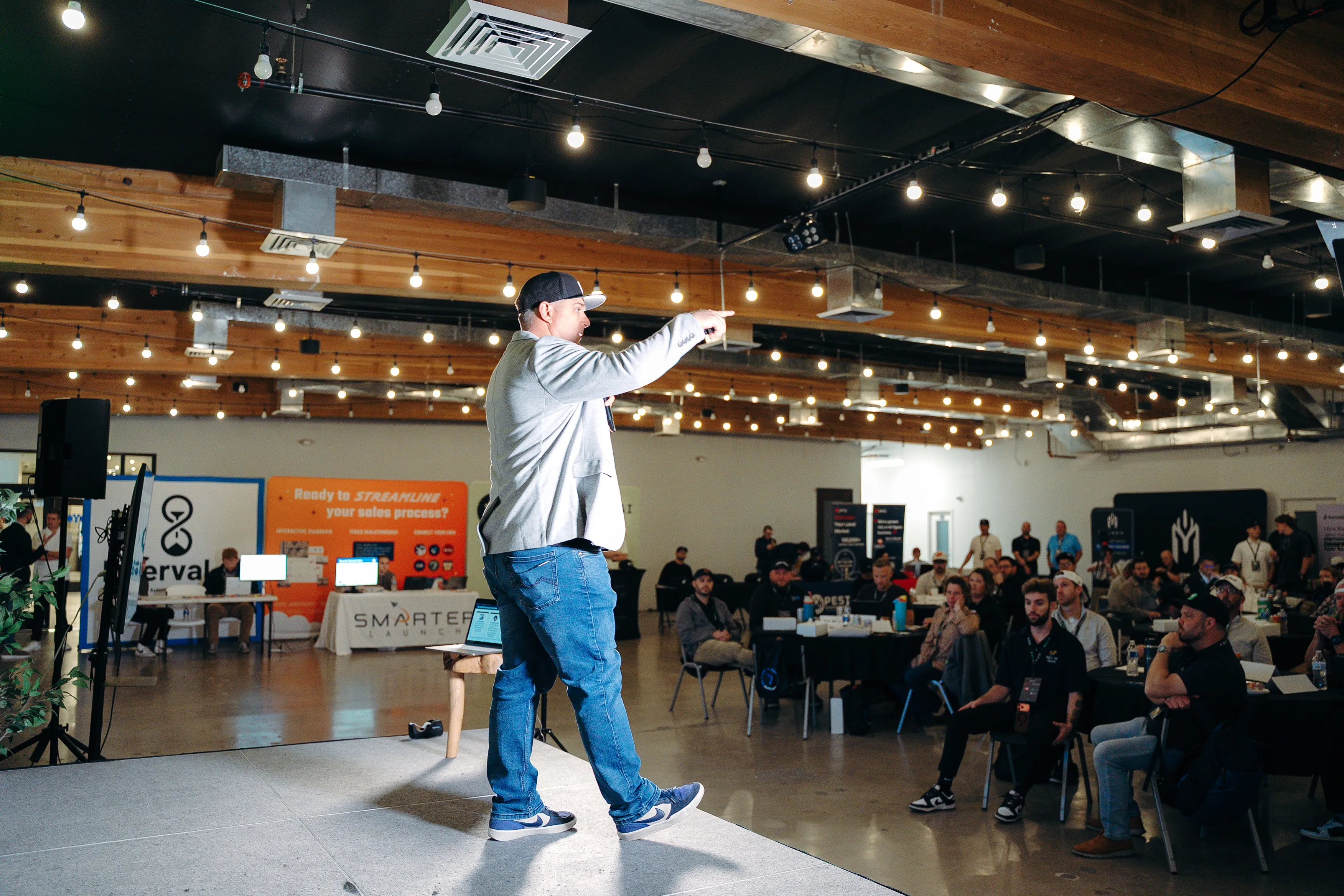 A presenter on stage speaking to owners at Bug Bux Con