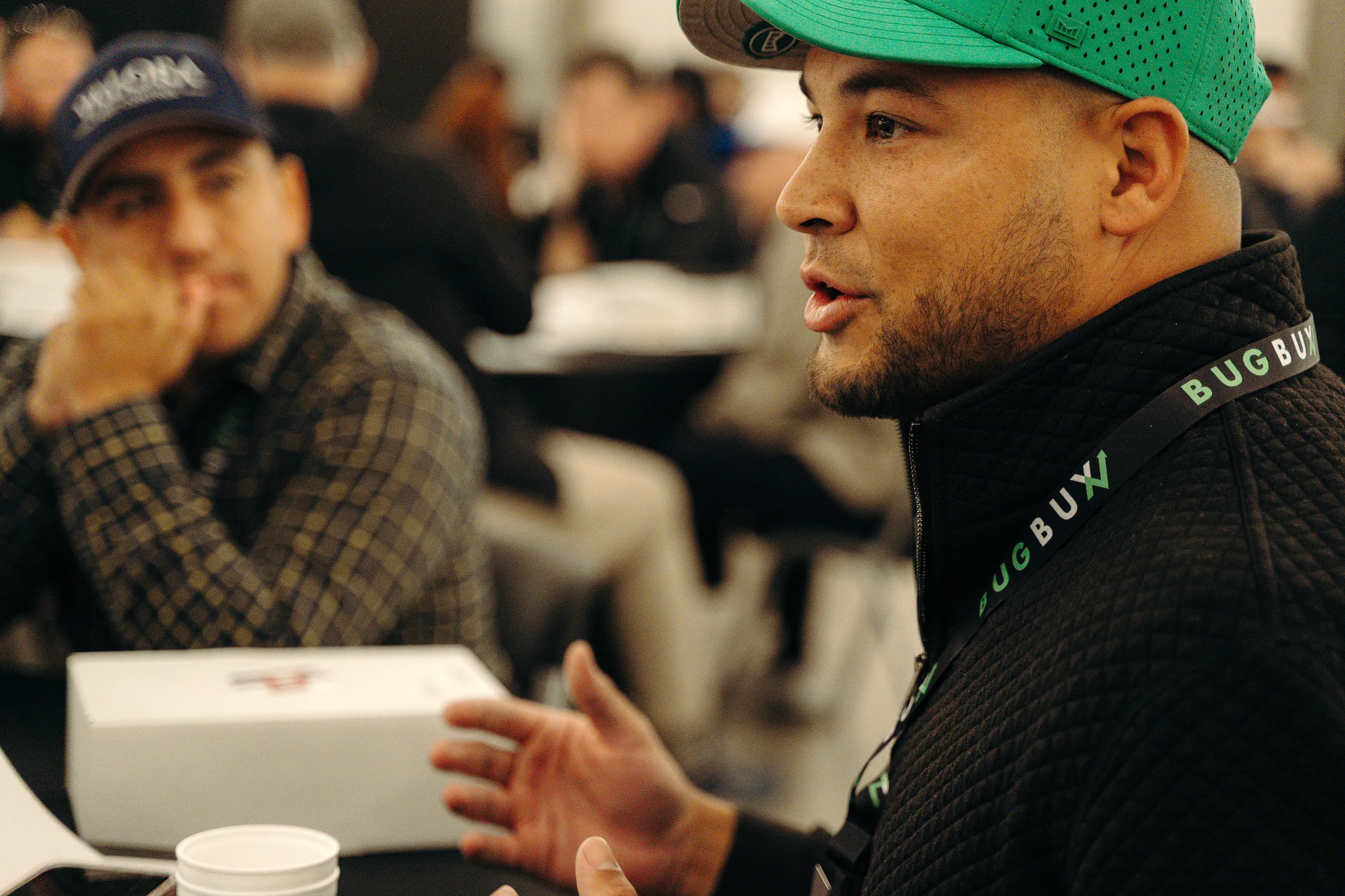 A Bug Bux+ member in Bug Bux gear talking with other pest control owners at a Bug Bux event